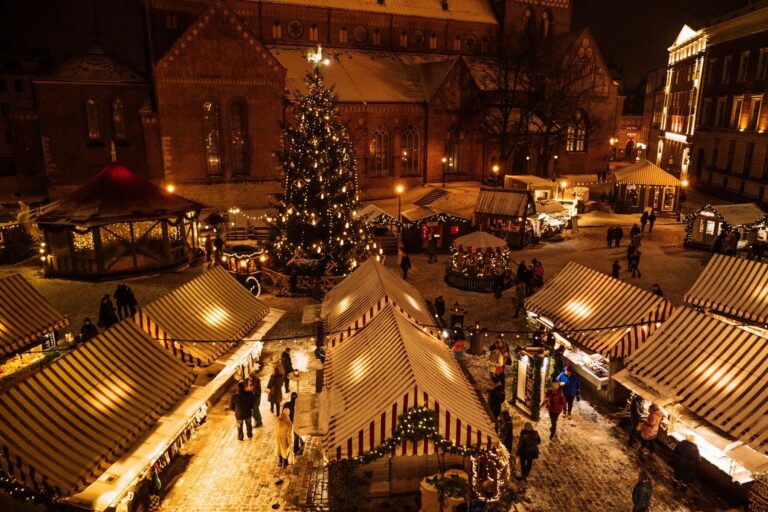 A European Christmas market at night, tree and stalls aglow